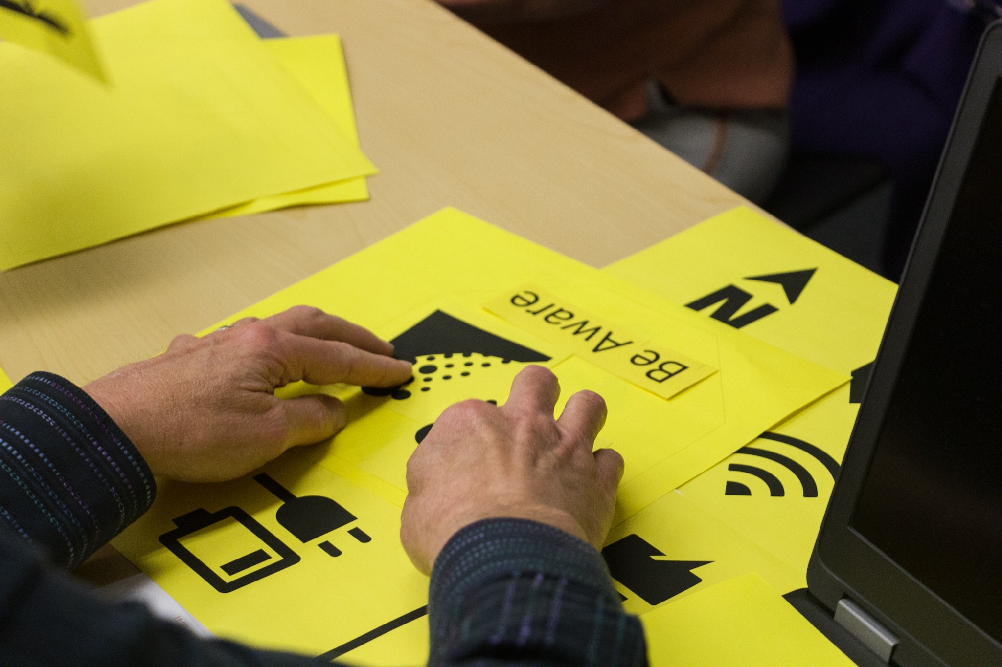 The hands of a workshop participant recreating visual icons.