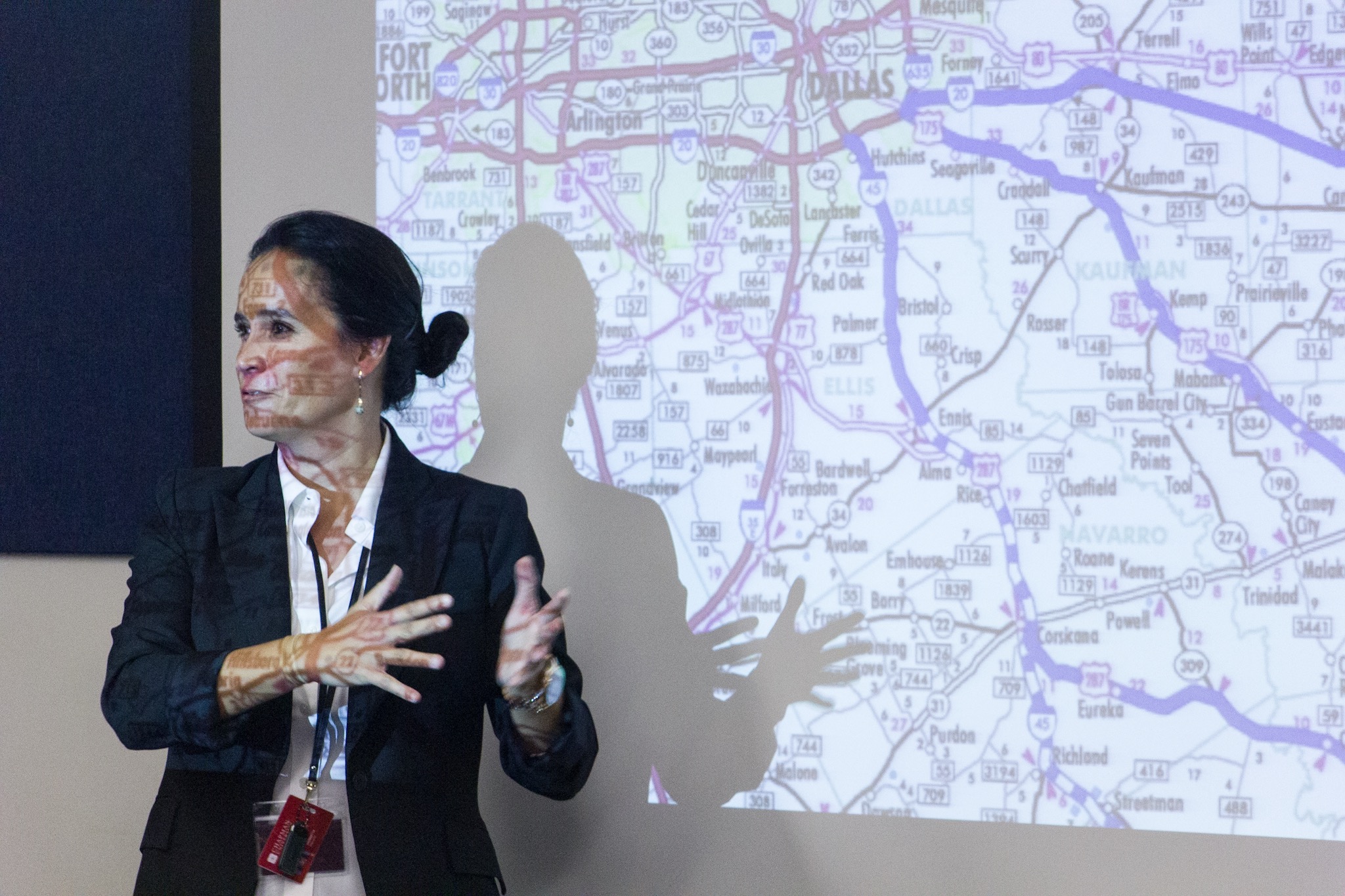 Claudine Jaenichen giving a lecture on cognition and information processing in times of crisis and showing a close-up an evacuation map. 