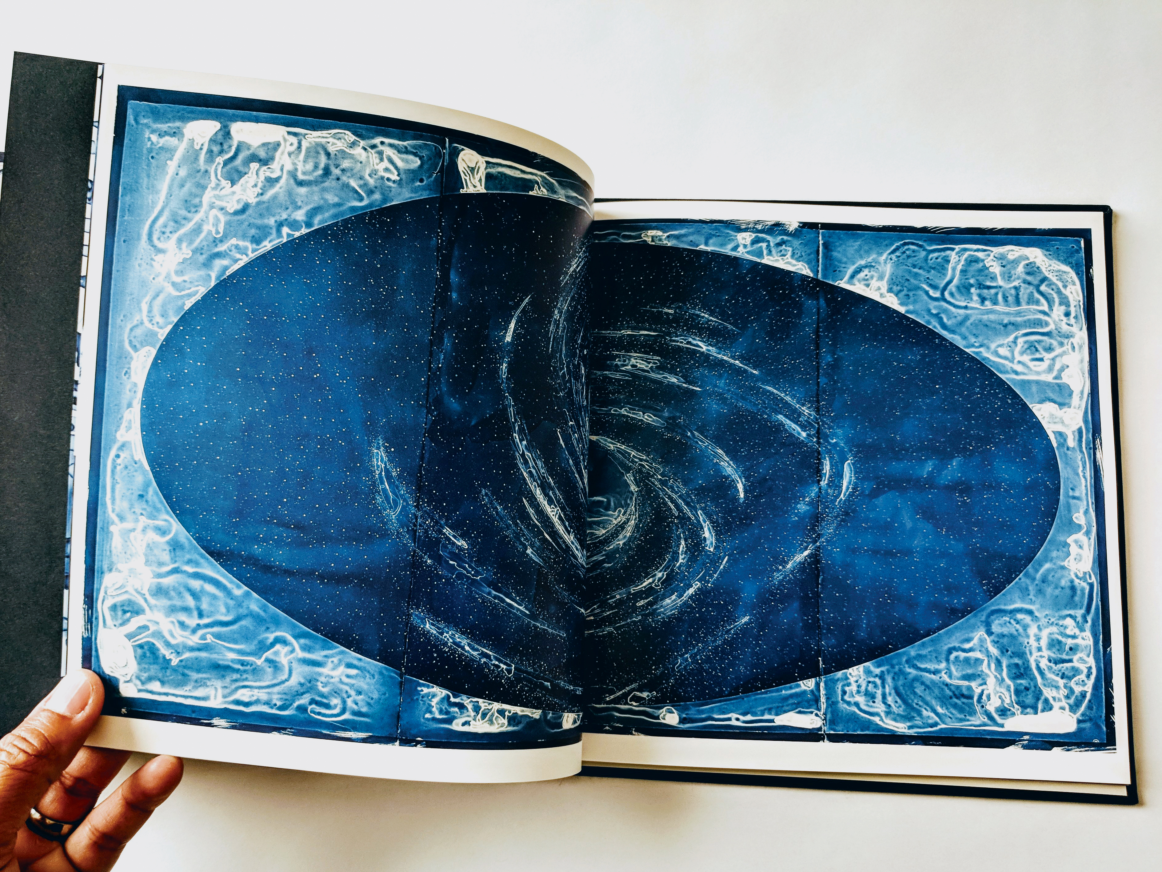 Open softcover art book showing one of Lia's drawings.