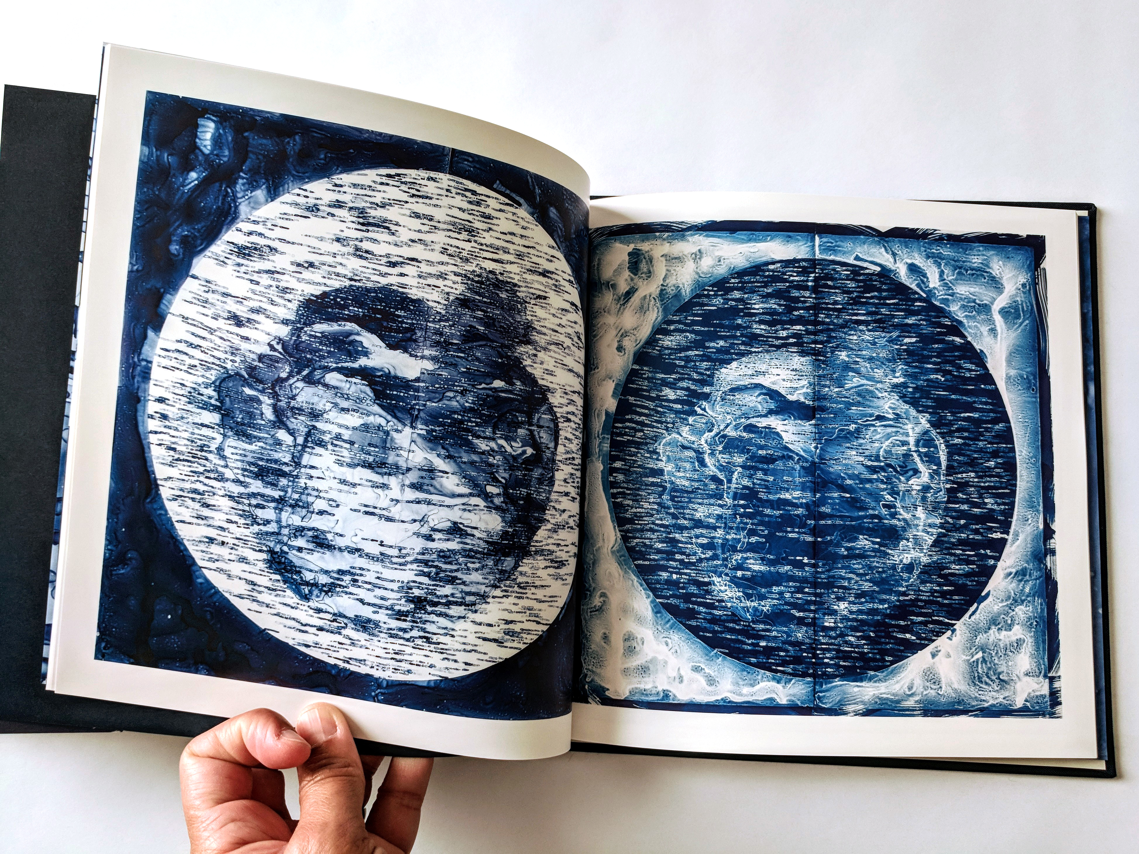 Open softcover art book showing two of Lia's drawings.